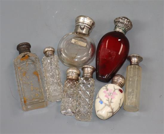 Eight assorted silver/white metal mounted scent bottles, including ruby glass and porcelain, largest 9.8cm.